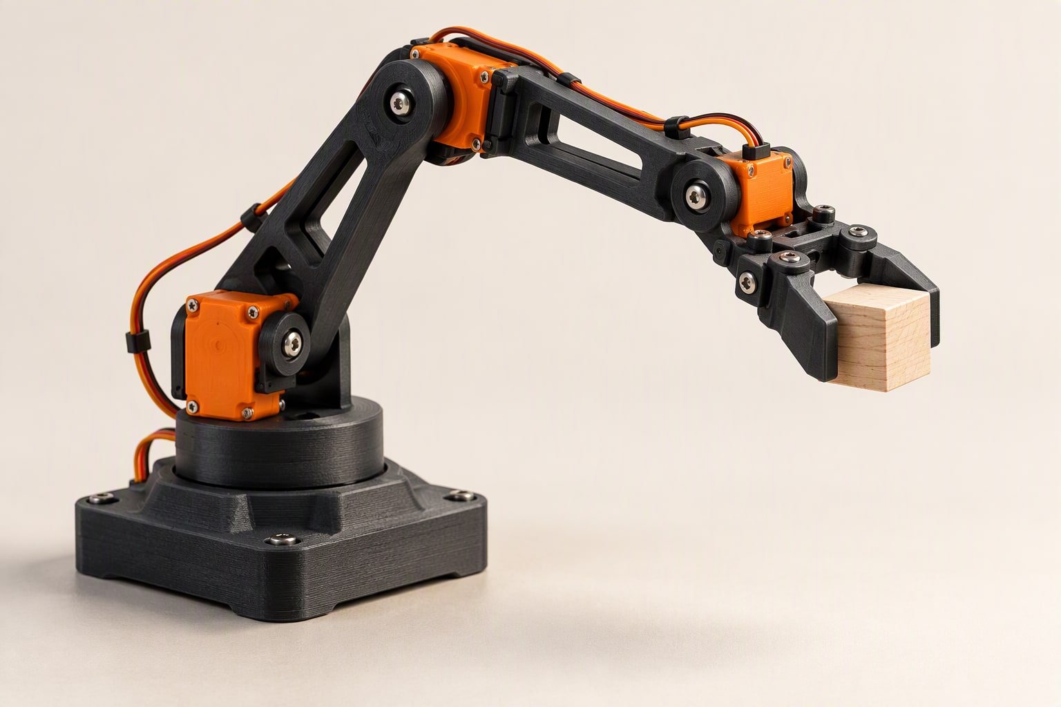 Small robot arm holding a block above a table